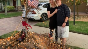  Kathy and David Thomas pose by their decorated debris pile on Friday, December 2, 2022.