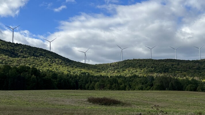 Seven of the 28 turbines that make up the Mars Hill Wind facility are viewed across a field from a road near the Maine-Canada border. The facility went operational 15 years ago, becoming New England’s first commercial wind power operation.