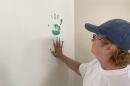 Maureen Maher-Gray touches a handprint on the wall of the art room in the NEPA Youth Shelter teen center.