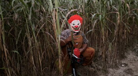A scary clown sits among the stalks at the Newberry Cornfield Maze, waiting to scare people.