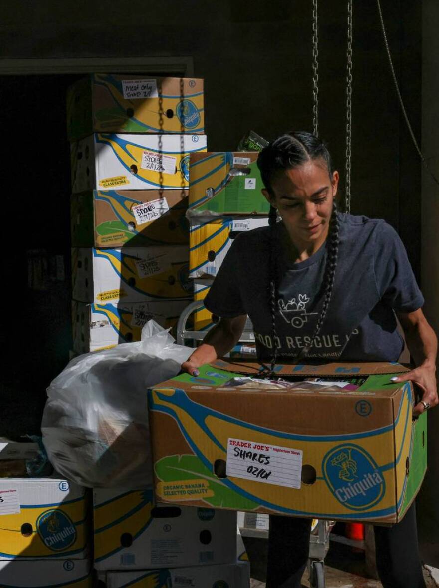 Food Rescue US volunteer Linda Diaz-Cobo picks up a box of food from Trader Joe’s that would otherwise be thrown out.