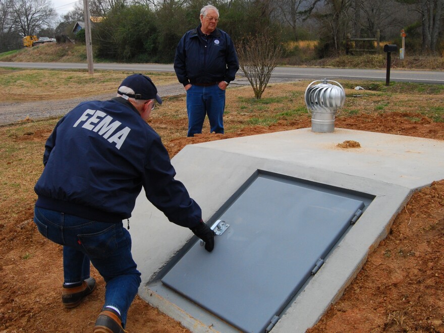 FEMA Public Information Officer, Nate Custer, left, and Resource Manager, Sterling Rich examine a newly installed storm shelter in Arkansas.