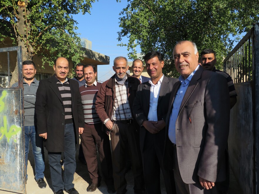 Yacoub Youssef (right) stands with employees at the electricity directorate in Jalawla. Local electrical workers figured out how to restore Jalawla's downed power lines and replaced missing transformers.