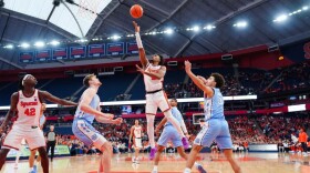 Orange guard JJ Starling (White, 2) goes up for the layup in between Tar Heels forward Henri Veesar (Blue, 13) and guard Derek Dixon (Blue, 3).