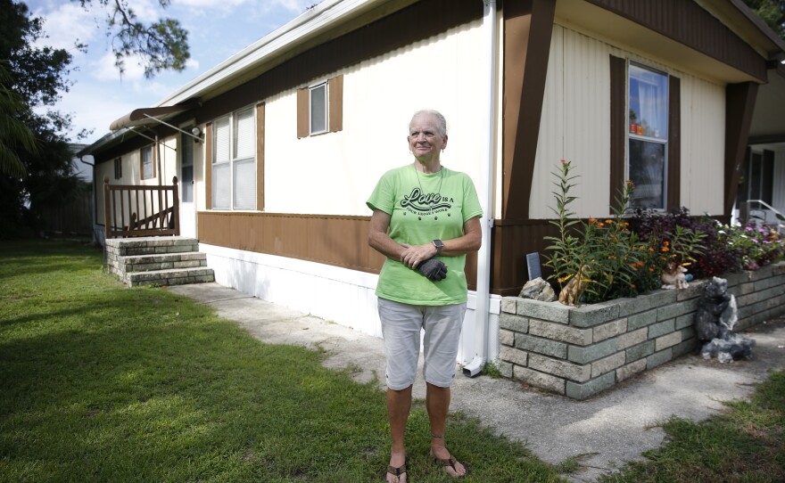 Janice Campbell poses for a photo in front of her home at Royal Palm Village in Haines City, Florida. Originally from the state, Campbell says she takes on odd jobs around the community to help offset the cost of living and rising lot rent.