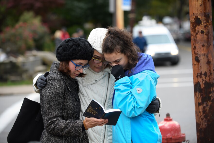 Tammy Hepps, Kate Rothstein and her daughter, Simone Rothstein, 16, pray from a prayerbook a block away from the site of a mass shooting at the Tree of Life Synagogue in the Squirrel Hill neighborhood.
