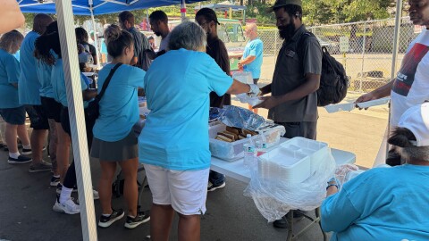 Volunteers serve lunch outside at the Roof Above Day Center. 