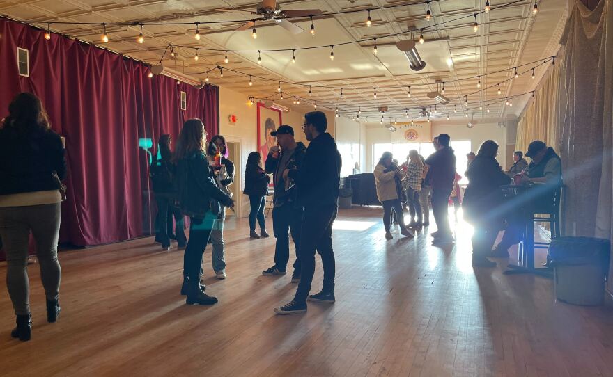 Upstairs at the PLAV 10, tour guests mingle. Along the red curtain and in other parts of the photo, an unexpected green light appeared. Oct 22, 2023.