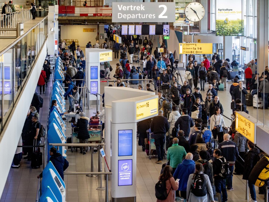 Passengers hoping to change their flights to the U.S. wait in long lines at Amsterdam Airport Schiphol in the Netherlands after President Trump announced new restrictions on travel from Europe.