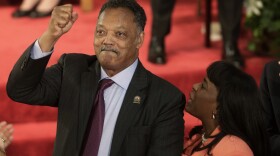 FILE - Rev. Jesse Jackson gestures to a friend in the balcony at the 16th Street Baptist Church in Birmingham, Ala., Sept. 15, 2013. The church held a ceremony honoring the memory of the four young girls who were killed by a bomb placed outside the church 50 years ago by members of the Ku Klux Klan. At right is U.S. Rep. Terri Sewell, D-Ala.