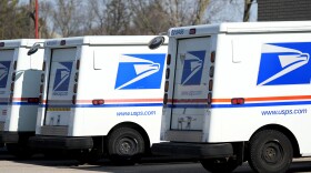 U.S. Postal Service trucks park outside a post office in Wheeling, Ill., Monday, Jan. 29, 2024. (AP Photo/Nam Y. Huh)