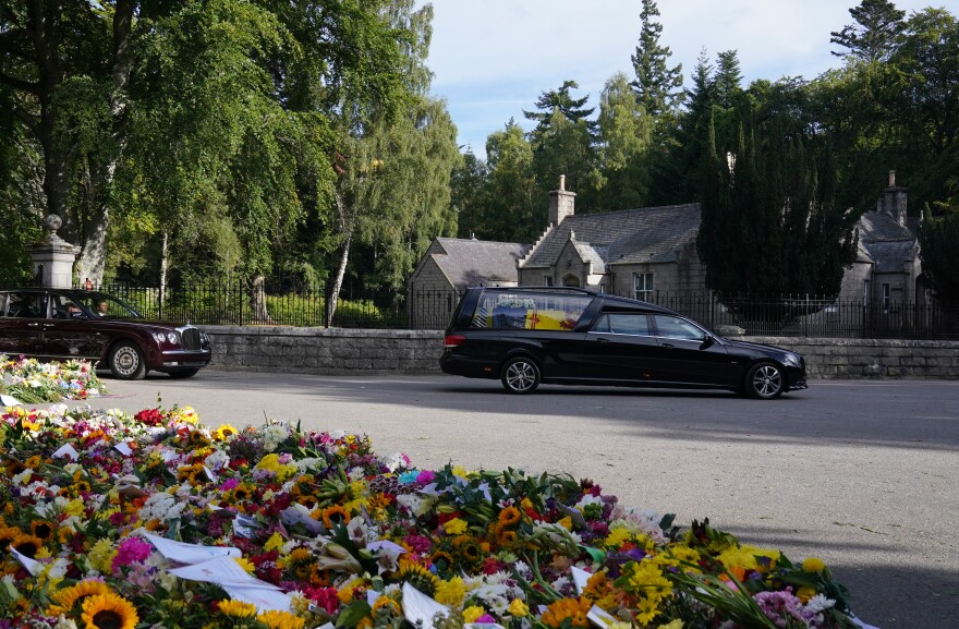 The hearse carrying the coffin of Queen Elizabeth II, draped with the Royal Standard of Scotland, leaving Balmoral as it begins its journey to Edinburgh. [Owen Humphreys  / PA Images via Getty Images]