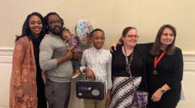 Jakari Harris proudly holds his clarinet alongside his family, band director and Karen Pearce. Pearce is a clarinet player on the Gainesville Community Band and was responsible for choosing Harris as this year's student-winner. (Sofia Mingote/WUFT News)