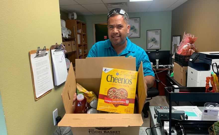 The Food Basket Operations Manager David Haʻalilio Jr. shows the contents of an emergency food box, which provides one day’s worth of food.