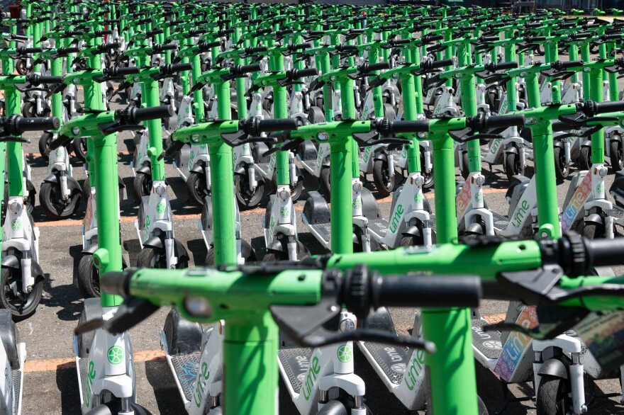 A collection of Lime scooters lined up.