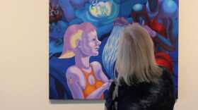 Viewer regards Delgado painting in Alliance for the Arts main gallery.