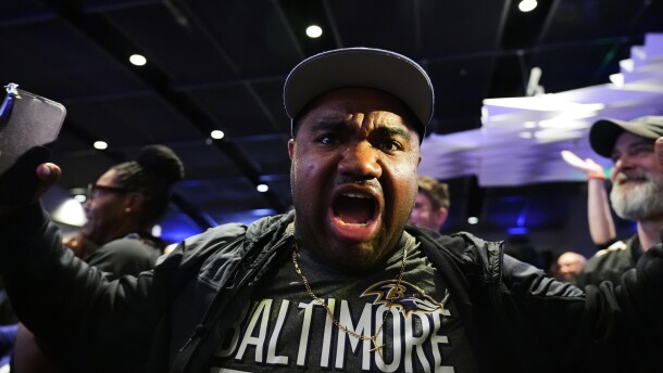 A Baltimore Ravens fan reacts to the team's first overall draft selection of guard Olaivavega Ioane during an NFL football draft party at M&T Bank Stadium in Baltimore, Thursday, April 23, 2026. (AP Photo/Stephanie Scarbrough)
