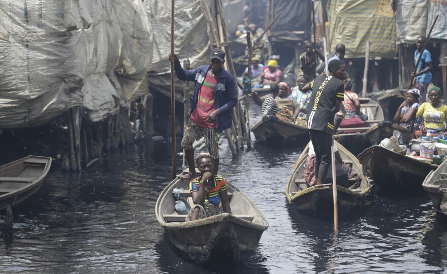 People travel by canoe in a poor neighborhood in Lagos, Nigeria. Lockdowns have begun in Africa as coronavirus cases rise. Nigeria has reported just over 100 coronavirus cases, though the actual number is likely much higher.
