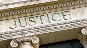 The word Justice is engraved on a court building