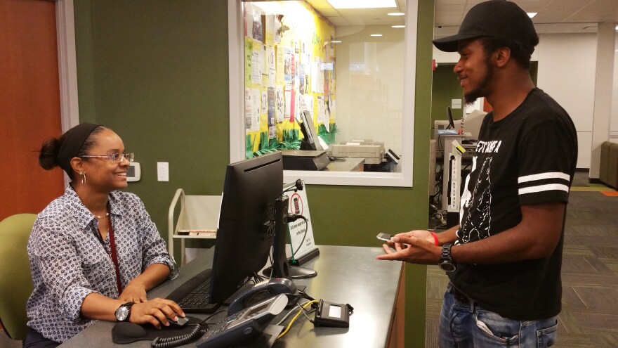Antonia McBride, the head of circulation at Harvey's public library helps a patron searching for a book.