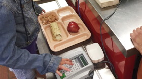 FILE - In this Thursday, May 4, 2017 file photo, a third-grader punches in her student identification to pay for a meal at Gonzales Community School in Santa Fe, N.M. The Trump administration is proposing a rollback of nutrition guidelines for federal school meals programs that had been promoted by Michelle Obama as part of her campaign to combat child obesity. (AP Photo/Morgan Lee, file)