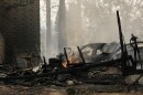A house on N. Victor St. and W. Lyons Ave. burned by a wildfire smolders, Sunday, Aug. 2, 2026, in Spokane, Wash. 
