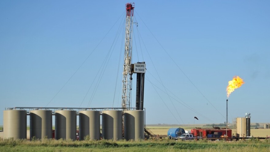 Natural gas is burned off next to an oil well being drilled at a site  near Tioga, N.D., in August. U.S. oil production started increasing a few years ago and is predicted to continue to rise, reducing the country's dependence on oil imports. 