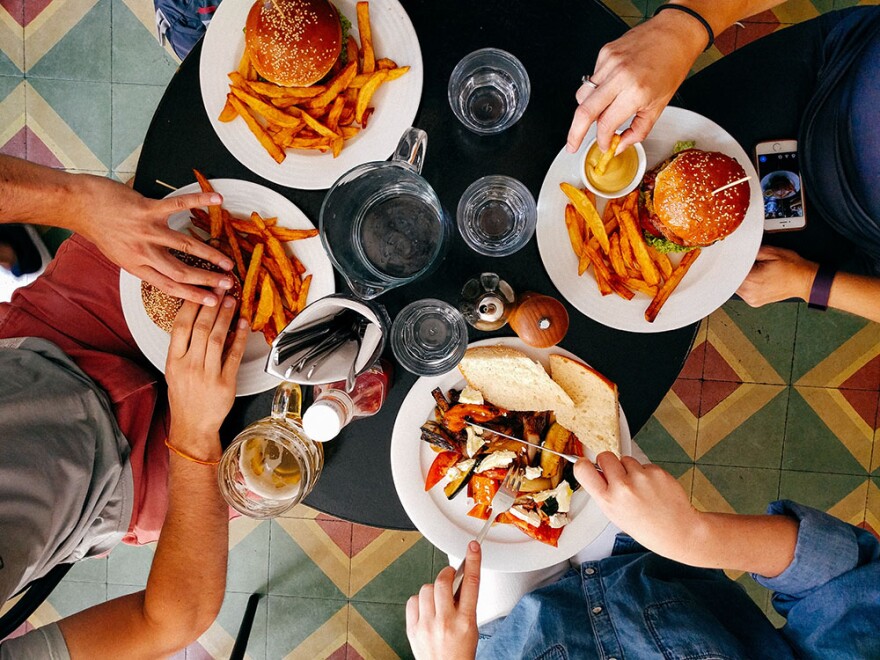 an overhead shot of people with burgers on their plate at a restaurant 