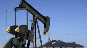 A pump jack works beside the site of new home construction in Midland, Texas. (Pat Sullivan/AP)