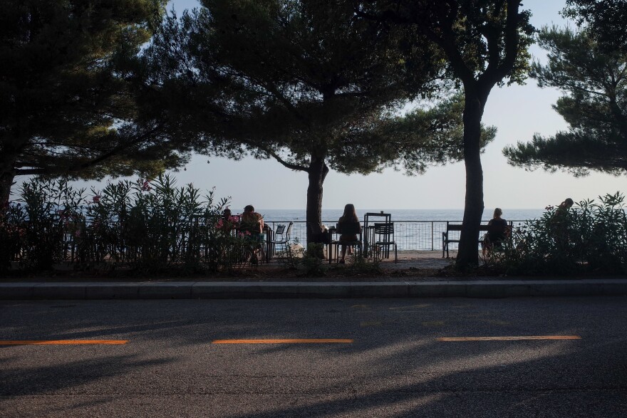 Built in the 1930s, a series of semicircular terraces lines the coast of Trieste where people enjoy the sea.