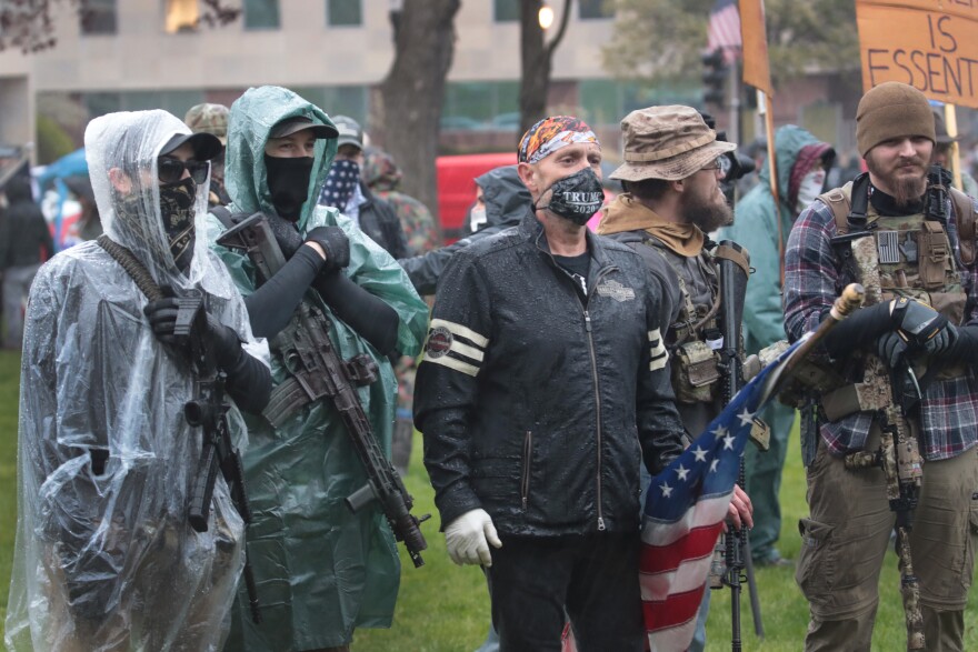 Demonstrators carrying guns hold a rally in front of the Michigan state capital building to protest the governor's stay-at-home order on May 14 in Lansing, Mich. Gov. Whitmer imposed the order to curtail the spread of COVID-19.