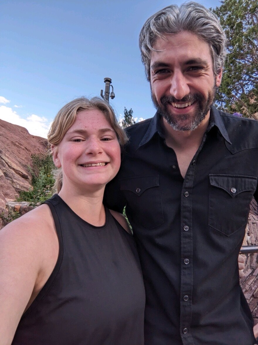 Greta Ravenhurst, a local teen, smiles with Gerardo Larios of Spoon during a concert at Red Rocks in Colorado on August 14, 2024.