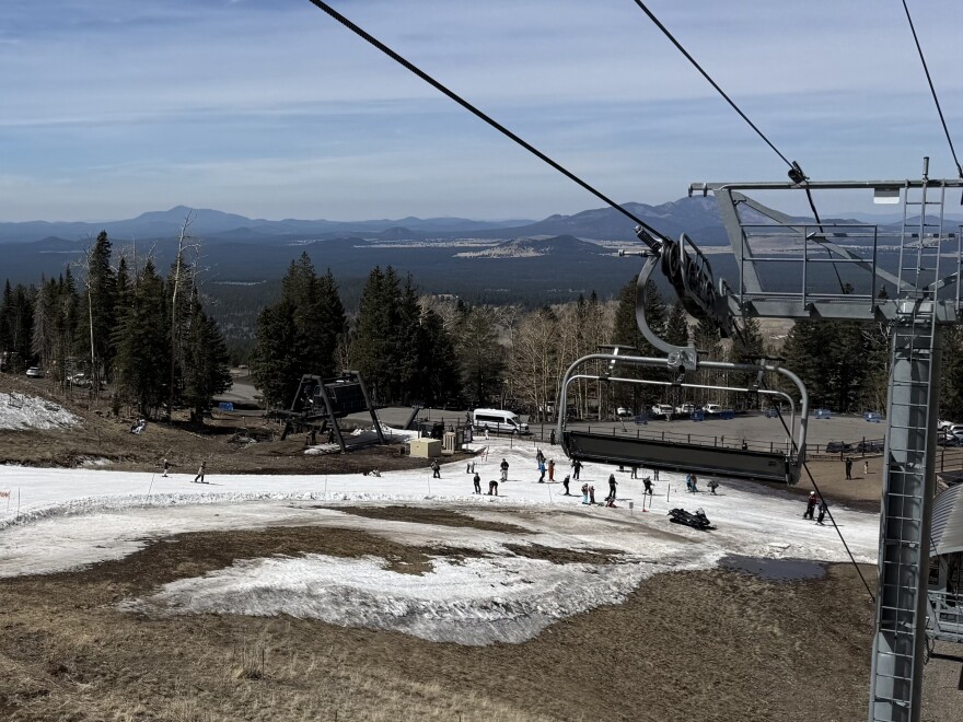 Skiers navigate a thin strip of snow at the Arizona Snowbowl near Flagstaff, Arizona on March 16, 2026. A hot, dry winter left mountains in the Colorado River Basin bereft of snow, which will strain the nation's largest reservoirs.
