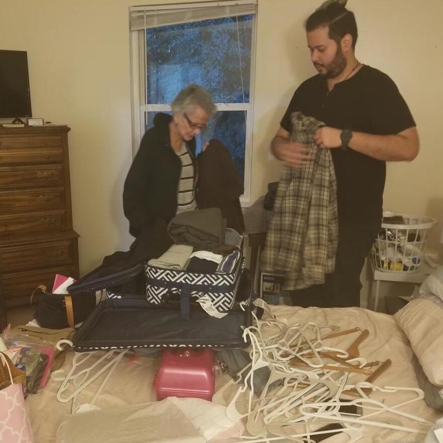 Juan Rojas, right, and his 69-year-old mother Margarita Rivera, left, pack clothing into suitcases before storing them in their closet to protect them from any water damage that might occur in the storm.