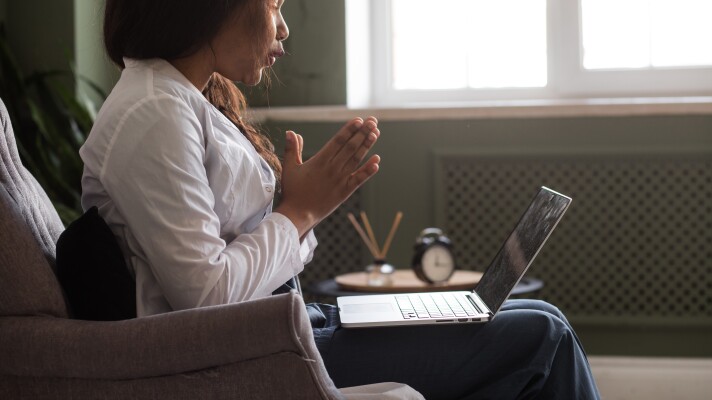 A woman participates in a telehealth appointment.