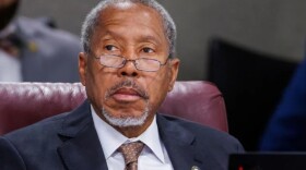 Black man with glasses and goatee looking to the left