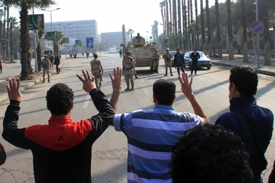 Cairo University students, who are supporters of the Muslim Brotherhood and deposed Egyptian President Mohamed Morsi, protest in front of security forces in Cairo on Jan. 10. The government has outlawed Morsi's political party and declared it a terrorist group.