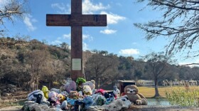 A cross with stuffed animals strewn at the base sits as a memorial in Hunt, Texas, not far from Camp Mystic on Dec. 26, 2025.