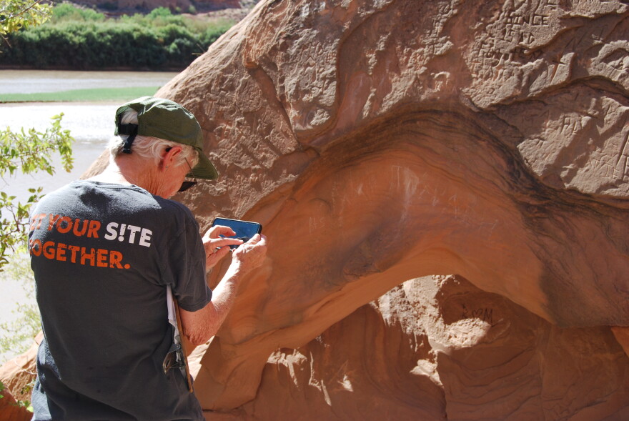 Smith photographs where visitors have scratched words and written things with permanent markers into the rock face — even though the rock is not part of the petroglyph panel itself.