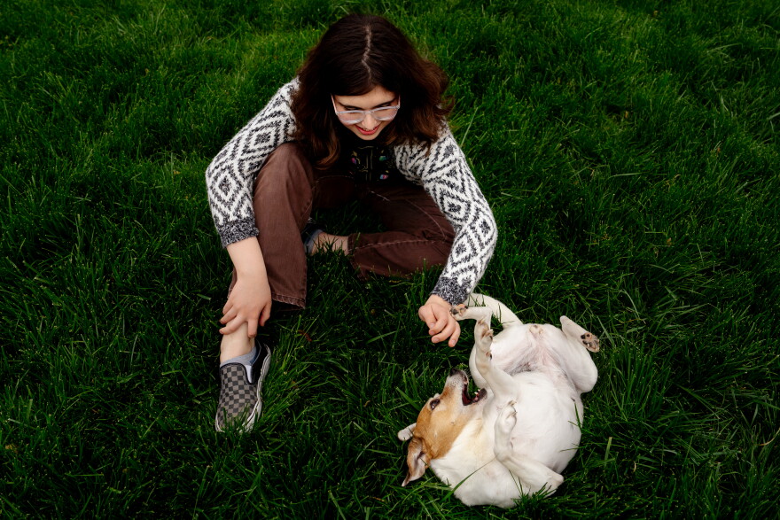 Chelsea Freels, 17, plays with “Sunny,” her 7-year-old Jack Russel Terrier, on Thursday, April 20, 2023, outside her home in Richmond Heights, Mo. Freels is one of the hundreds of transgender Missourians who have been targeted by anti-trans policies from Jefferson City.