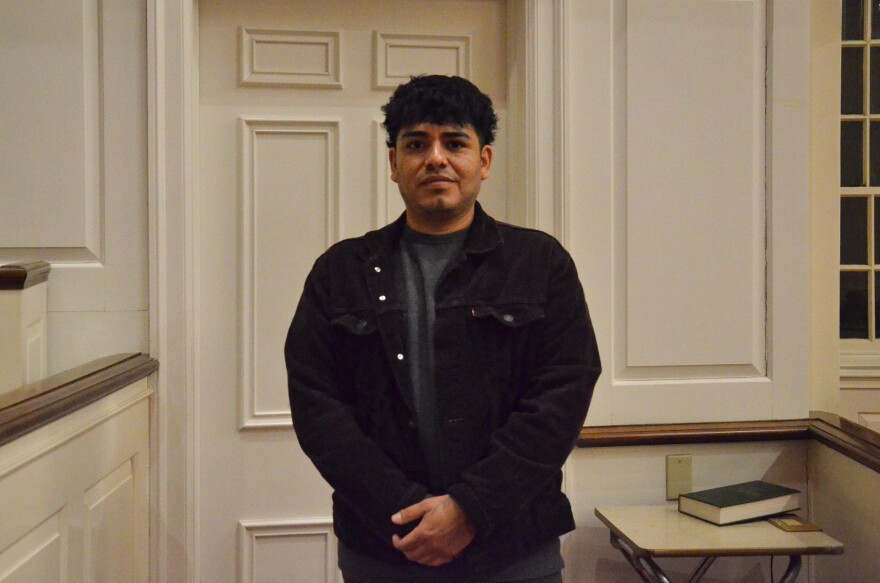 A man in a brown jacket poses for a photo.