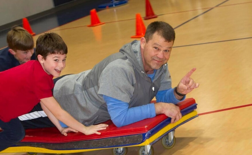  Jamie Seitz plays with students in his elementary P.E. class.