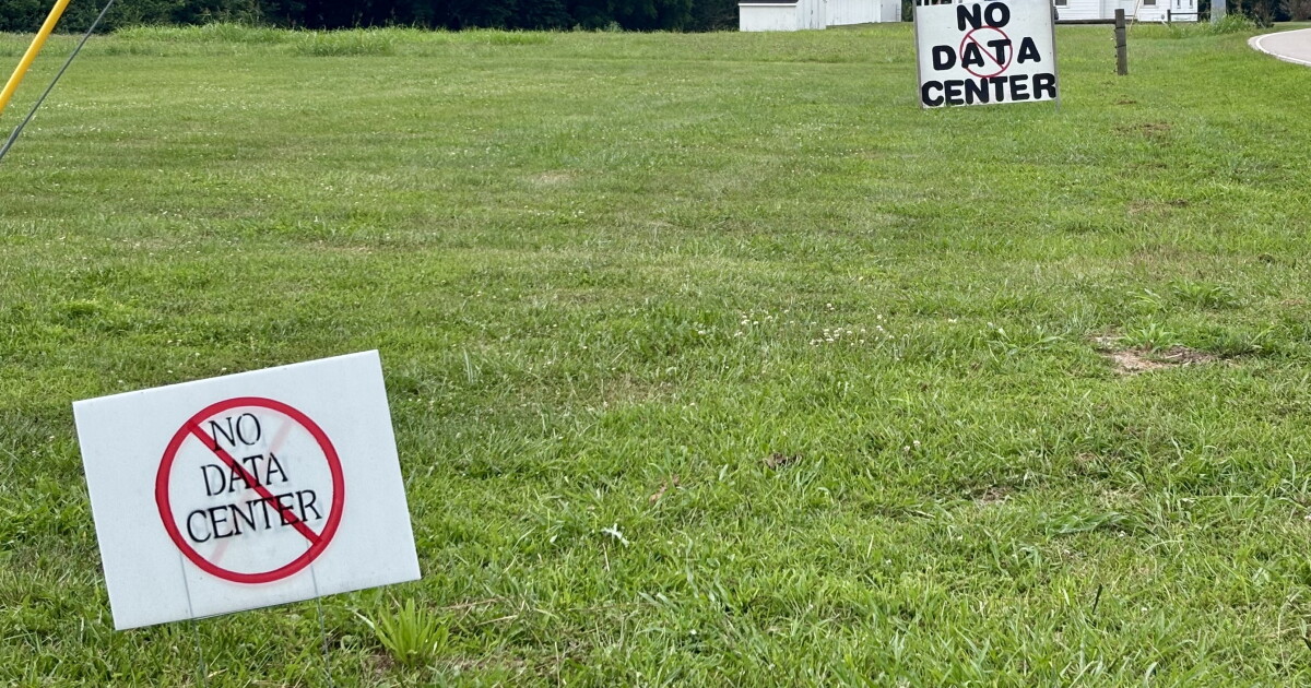 Two signs reading 'No data center' stand in a grassy field on Woodsdale Road in Trenton, Ohio, near the planned Prologis Project Mila site. Photo: Lilley Halloran/WVXU