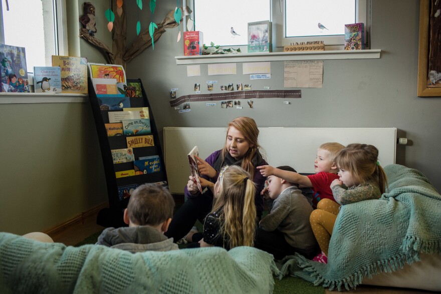 Colleen Macleod reads to children at Pairc Playgroup in South Lochs. The childcare center offers bilingual learning and says the mobile library is critical for access to Gaelic children's books. "As educators, we use it for resources and that keeps the culture alive as well," says teacher Kayleigh Makillop.