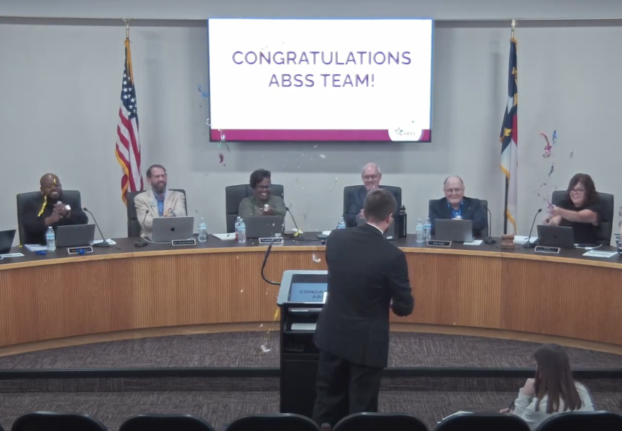 Alamance-Burlington School System board of education members cheered and threw confetti in celebration of the district coming off the state's low-performing list.