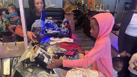 A young girl in a pink hoodie looking at a selection of costumes 