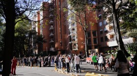People stand outside their homes after a quake was felt in Bogota, Colombia, Monday, Aug. 10, 2026.
