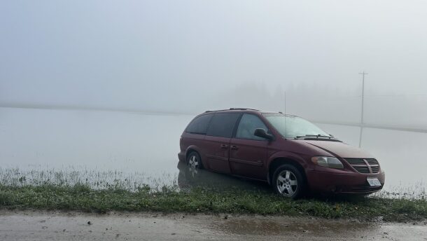 A minivan is stuck after flooding along Tualco Road near Monroe, Wash. on Saturday, Dec. 13, 2025. The Northwest is seeing warm rains instead of snow in much of the region, concerning climate scientists.