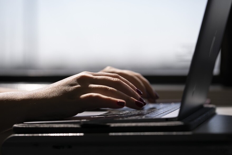 A woman types on a laptop on a train in New Jersey. (Jenny Kane/AP)