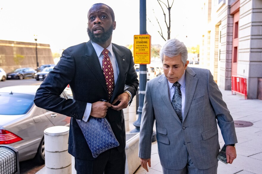 Prakazrel "Pras" Michel (left), a member of the 1990s hip-hop group the Fugees, accompanied by defense lawyer David Kenner arrives at federal court April 3, 2023, in Washington.